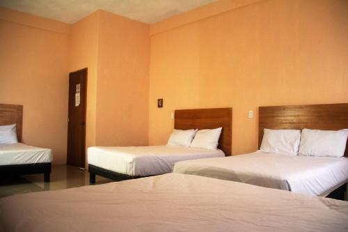 a hotel room with two beds with white sheets at OYO Hotel Trigos De Oro,San Luis Teolocholco Park in San Luis Teolocholco