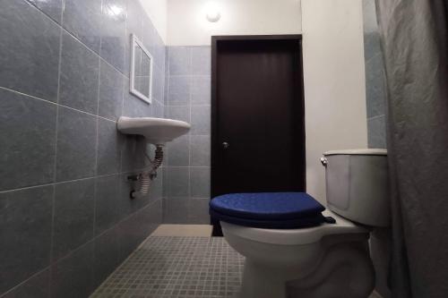 a bathroom with a toilet with a blue seat at OYO Hotel Trigos De Oro,San Luis Teolocholco Park in San Luis Teolocholco