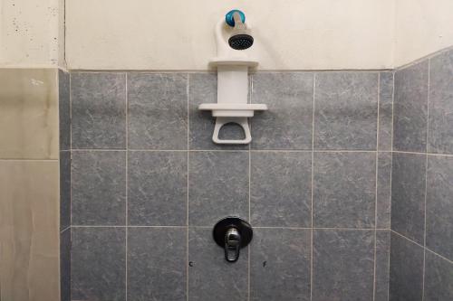 a shower with a shower head on a tiled wall at OYO Hotel Trigos De Oro,San Luis Teolocholco Park in San Luis Teolocholco
