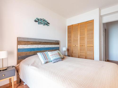 une chambre avec un grand lit avec une tête de lit en bois dans l'établissement Apartment Baie des Lecques by Interhome, à Saint-Cyr-sur-Mer