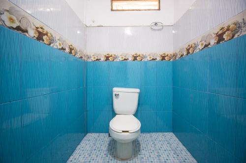 a blue bathroom with a white toilet in it at OYO Cabañas Abril, Mazunte in Mazunte
