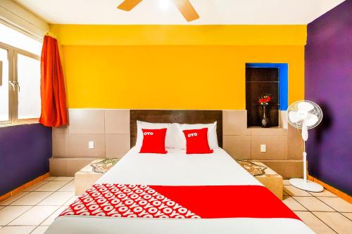 a bedroom with a large bed with red pillows at OYO Hotel Rey David, Oaxaca in Ocotlán de Morelos