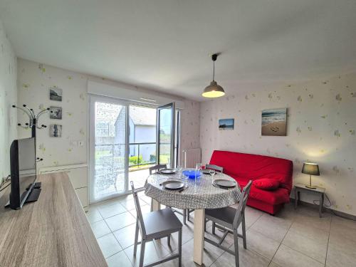 un salon avec une table et un canapé rouge dans l'établissement Apartment Le Clos Bastille by Interhome, à Saint-Malo
