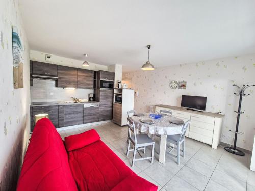 un salon avec un canapé rouge et une cuisine dans l'établissement Apartment Le Clos Bastille by Interhome, à Saint-Malo