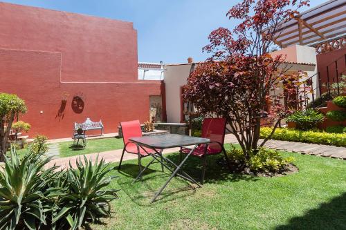 a table and chairs in a yard with a building at Collection O Cachito Mio in Cholula