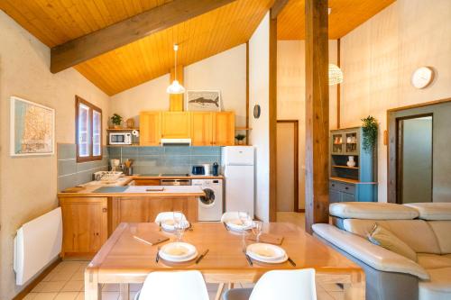 une cuisine avec une table en bois et une salle à manger dans l'établissement Chardons bleus - villa 6p, à Capbreton