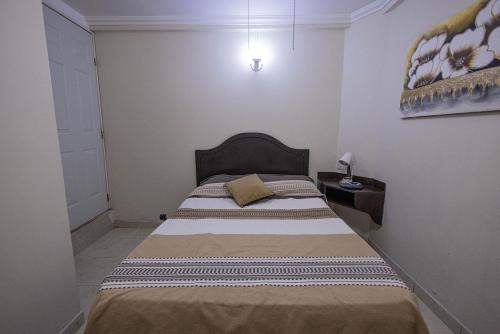 ein Schlafzimmer mit einem großen Bett in einem Zimmer in der Unterkunft Capital O Hotel Patio Pombo in Oaxaca de Juárez