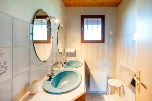 une salle de bain avec un lavabo bleu et un miroir dans l'établissement Chardons bleus - villa 6p, à Capbreton