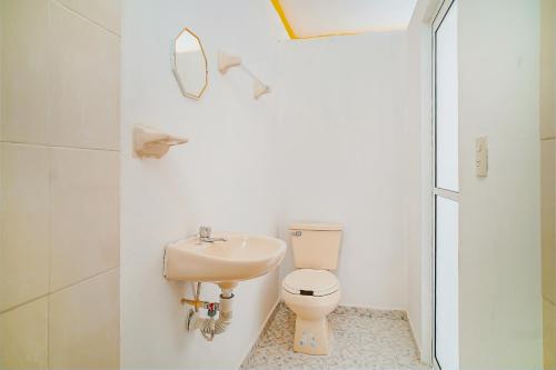 a white bathroom with a toilet and a sink at OYO Hospedaje Colibri in Chiapa de Corzo
