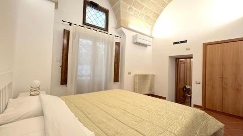 een slaapkamer met een groot wit bed met een raam bij Casa Ginevra, private Parking in Lecce
