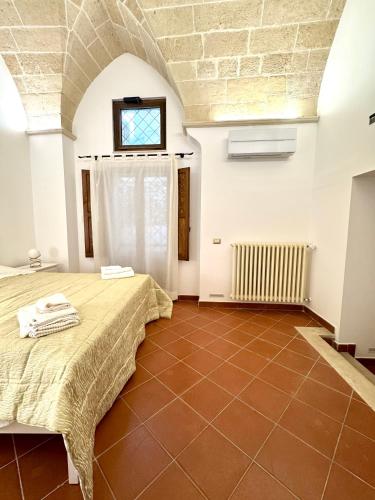 a bedroom with a bed and a brick wall at Casa Ginevra, Private Garage, Vaulted Ceilings in Lecce