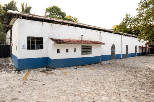 a white and blue building with a courtyard at OYO Posada Astrud,Cuetzalan in Cuetzalán del Progreso
