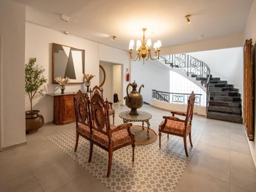 a living room with a table and chairs and a staircase at Collection O Hotel Lavanda Anzures in Mexico City