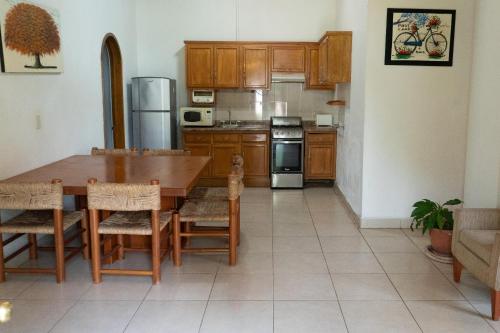 a kitchen with a table and a kitchen with a refrigerator at Capital O La Joya Del Lago in Ajijic
