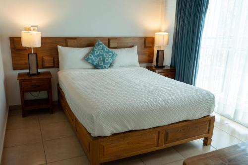 a bedroom with a large bed with two night stands at Capital O La Joya Del Lago in Ajijic