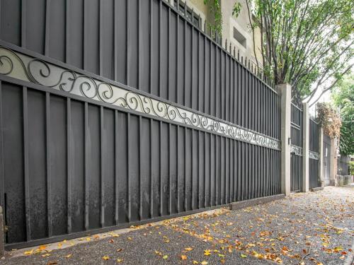 a black fence next to a street with leaves on the ground at Collection O Hotel Lavanda Anzures in Mexico City