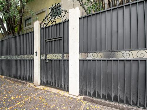 a black fence with a gate in front of a house at Collection O Hotel Lavanda Anzures in Mexico City