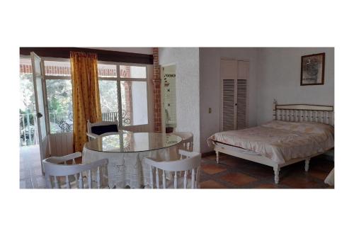a bedroom with a bed and a table and chairs at Capital O Posada Del Pescador Jocotepec in Chapala