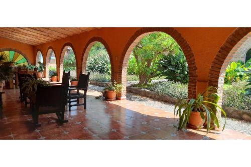 an outdoor patio with a table and chairs and plants at Capital O Posada Del Pescador Jocotepec in Chapala