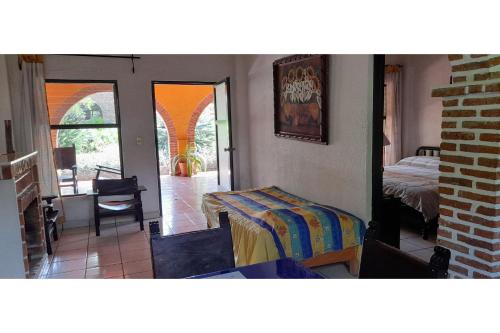 a bedroom with a bed and a table in a room at Capital O Posada Del Pescador Jocotepec in Chapala