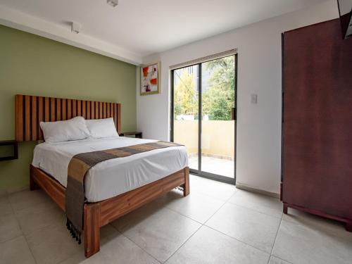a bedroom with a bed and a large window at Collection O Hotel Lavanda Anzures in Mexico City