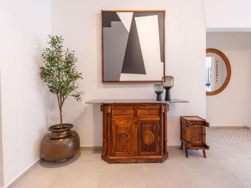 a wooden cabinet with a mirror and a potted plant at Collection O Hotel Lavanda Anzures in Mexico City