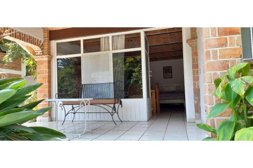 a porch with a bench in front of a door at Capital O Posada Del Pescador Jocotepec in Chapala