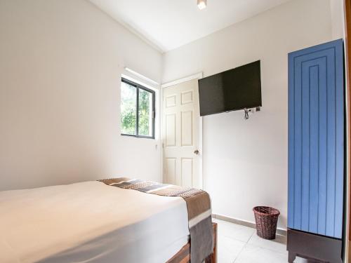 a bedroom with a bed and a flat screen tv at Collection O Hotel Lavanda Anzures in Mexico City