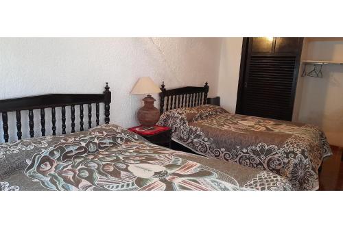 two beds sitting next to each other in a bedroom at Capital O Posada Del Pescador Jocotepec in Chapala