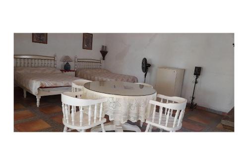 a room with a table and chairs and a bed at Capital O Posada Del Pescador Jocotepec in Chapala