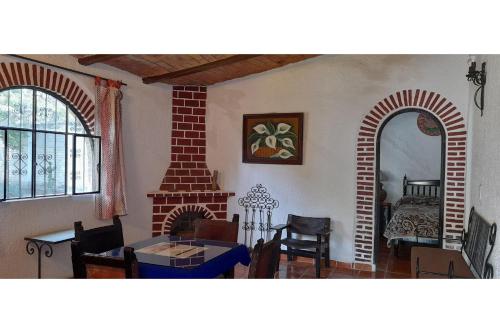 a living room with a fireplace and a table and chairs at Capital O Posada Del Pescador Jocotepec in Chapala
