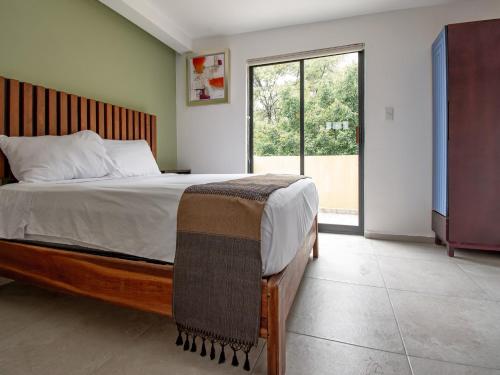 a bedroom with a large bed and a large window at Collection O Hotel Lavanda Anzures in Mexico City