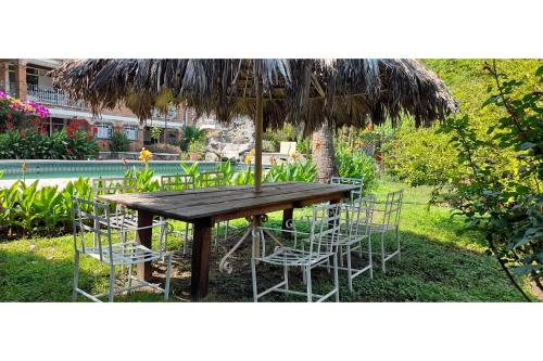 a wooden table and chairs under an umbrella at Capital O Posada Del Pescador Jocotepec in Chapala