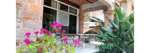 a balcony with a table and flowers in front of a building at Capital O Posada Del Pescador Jocotepec in Chapala