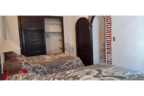 a hotel room with two beds and a mirror at Capital O Posada Del Pescador Jocotepec in Chapala