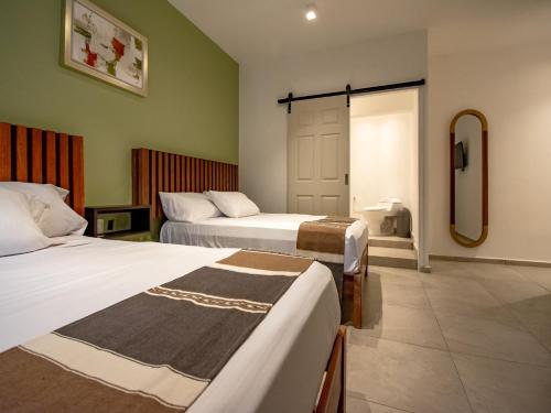 a hotel room with two beds and a bathroom at Collection O Hotel Lavanda Anzures in Mexico City