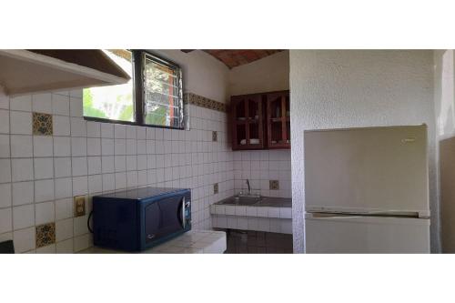 a kitchen with a refrigerator and a tv in it at Capital O Posada Del Pescador Jocotepec in Chapala