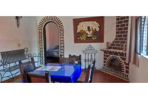 a living room with a table and a fireplace at Capital O Posada Del Pescador Jocotepec in Chapala