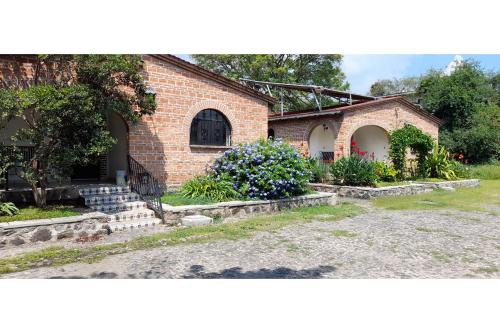 a brick house with some flowers in the yard at Capital O Posada Del Pescador Jocotepec in Chapala
