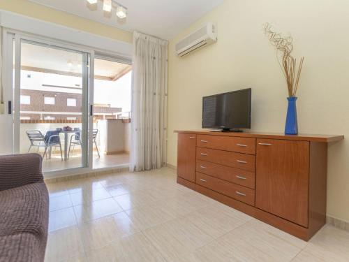 a living room with a television on a wooden dresser at Apartment Playa Coral I-1 by Interhome in Oropesa del Mar