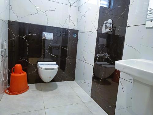 a bathroom with a toilet and a sink at Hotel Jeyam in Kanyakumari