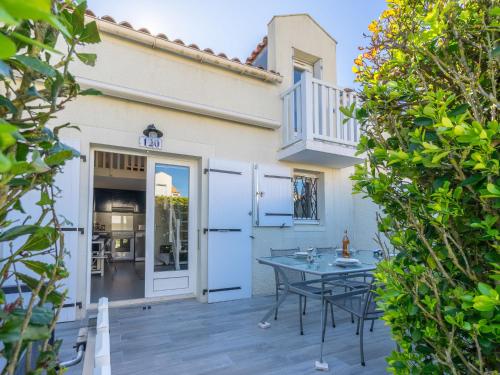 a patio with a table in front of a house at Holiday Home Les Jardins de l'Océan-38 by Interhome in Pontaillac