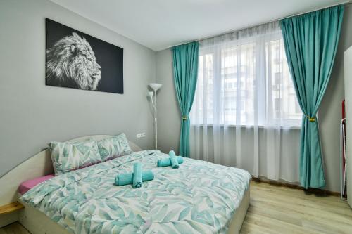a bedroom with a bed with blue sheets and a window at By The Sea - central with free parking in Varna City