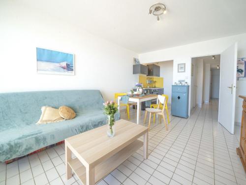 un salon avec un canapé bleu et une table dans l'établissement Apartment Poséidon by Interhome, à La Grande Motte