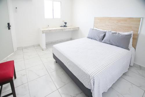 1 dormitorio con 1 cama con silla roja y mesa en OYO Hotel Plaza Las Torres, Cabo San Lucas, en Cabo San Lucas