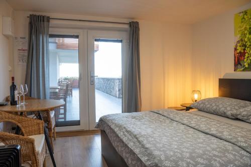 a bedroom with a bed and a table and a balcony at Vinařství U sv. Kříže in Prušánky