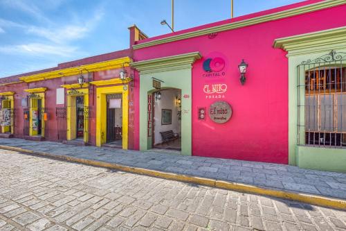 a row of colorful buildings on a street at Capital O El Nito Posada in Oaxaca City