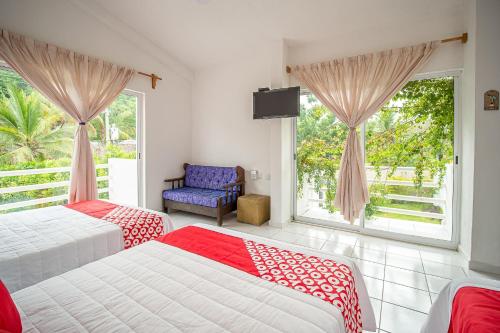 a bedroom with two beds and a window at OYO Hotel Posada San Vicente, Huatulco in Santa Maria Huatulco