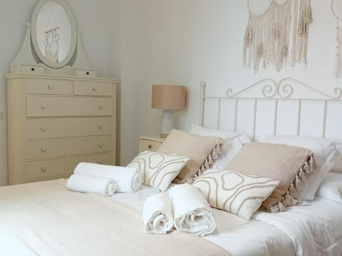 two white beds in a bedroom with a dresser at Casa El Azud La Cañada 1 minuto metro in Partida de La Cañada