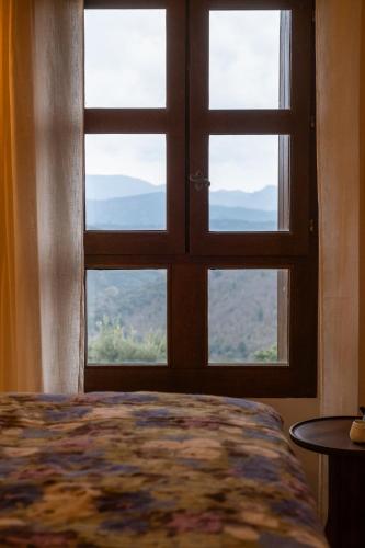 a bedroom with a window with a bed and a table at Les Terrasses de la Borie in Mandagout